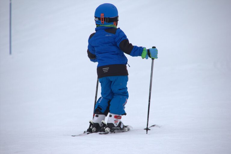 Auf dem Bild ist ein kleines Kind in Skiausrüstung zu sehen.